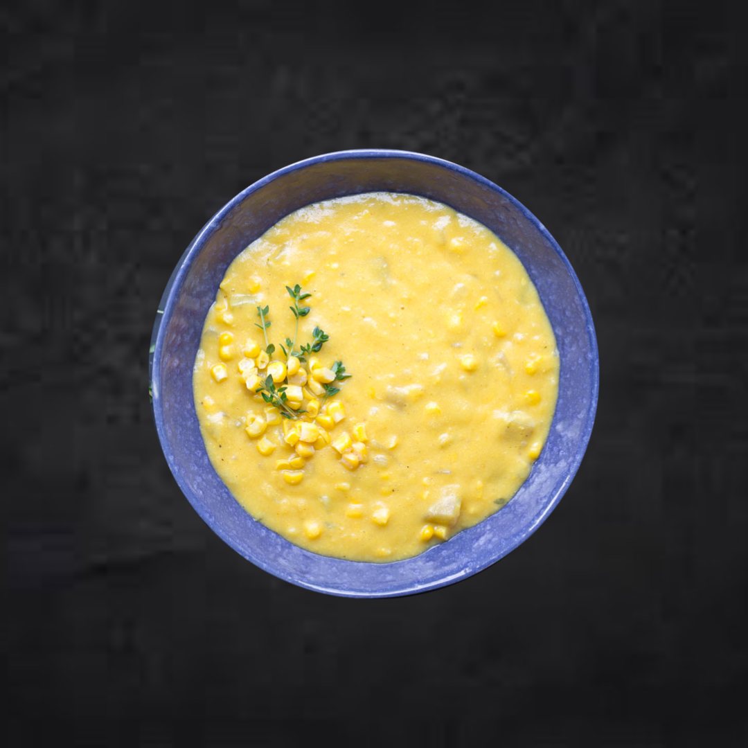 Potato & Corn Chowder in a blue bowl by Fierce Fuel, offering healthy prepped meals.