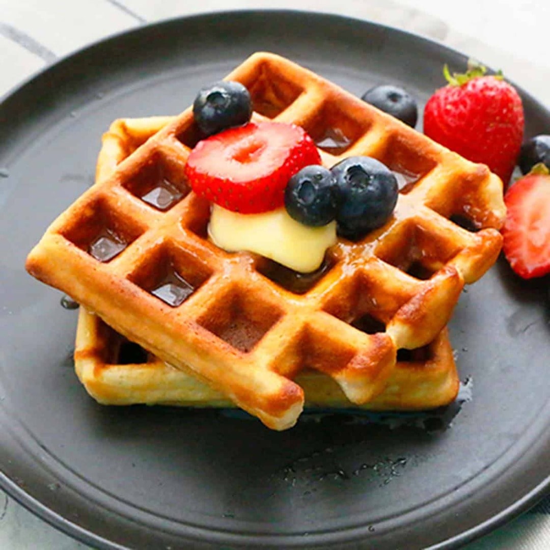 Fierce Fuel Protein Waffles with berries and butter served on a black plate in Squamish.