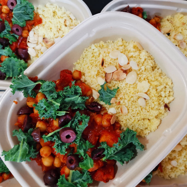 A plate of Moroccan Chickpea Stew & Toasted Almond Cous Cous from Fierce Fuel, kale, and olives, available for delivery in Whistler.