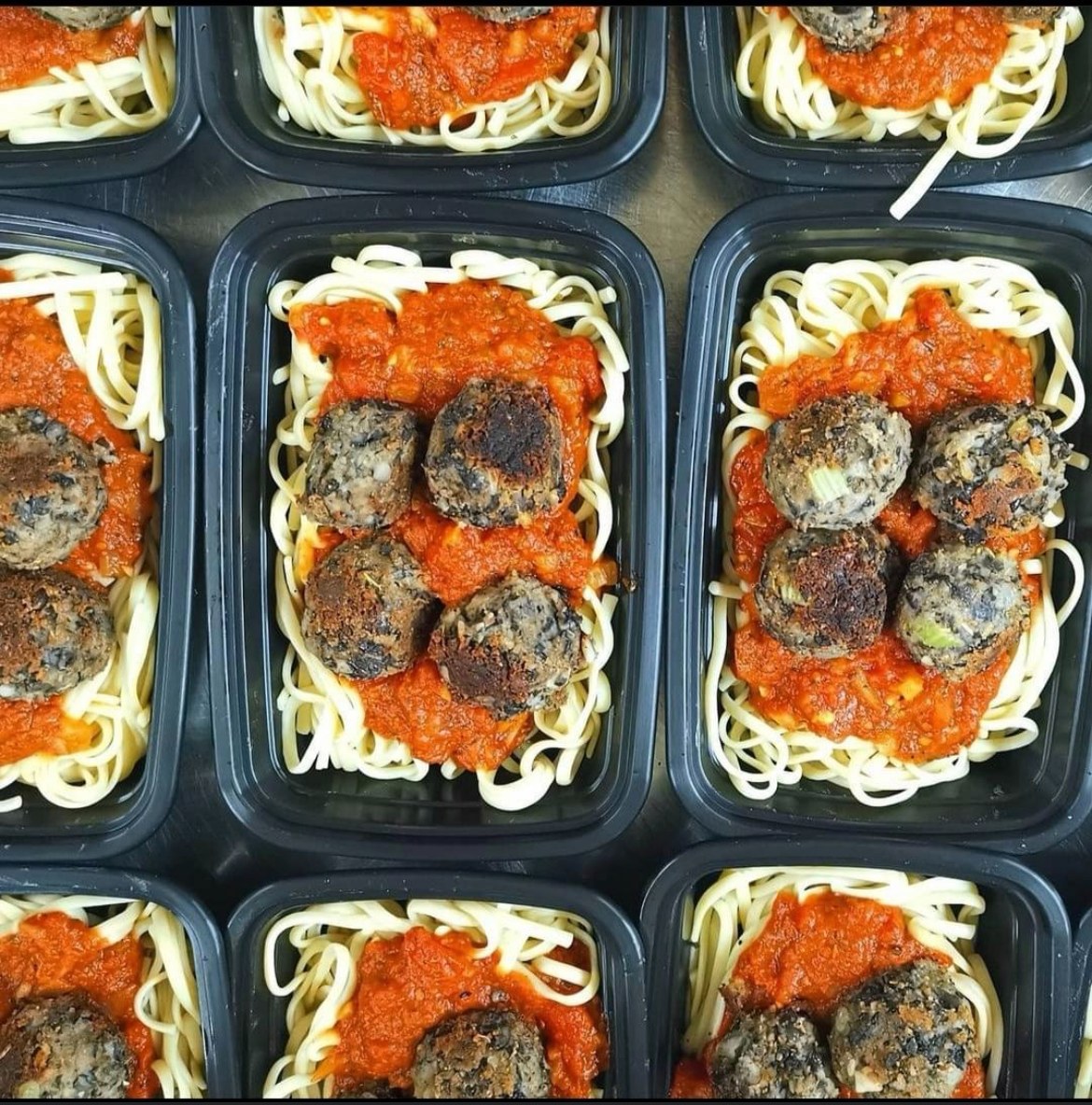 A group of containers of Fierce Fuel black bean meatballs and organic spaghetti.